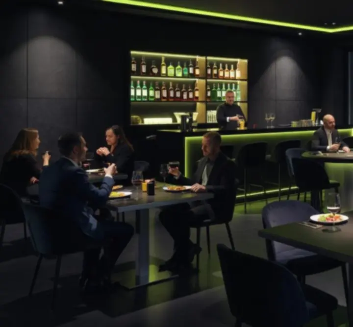 Nowoczesne wnętrze E.W.T nocą z neonowym podświetleniem i stolikami pokerowymi